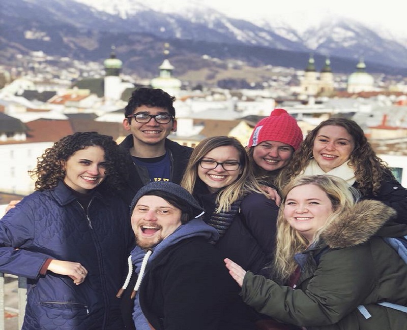 group of students posing in front of mountains in austria